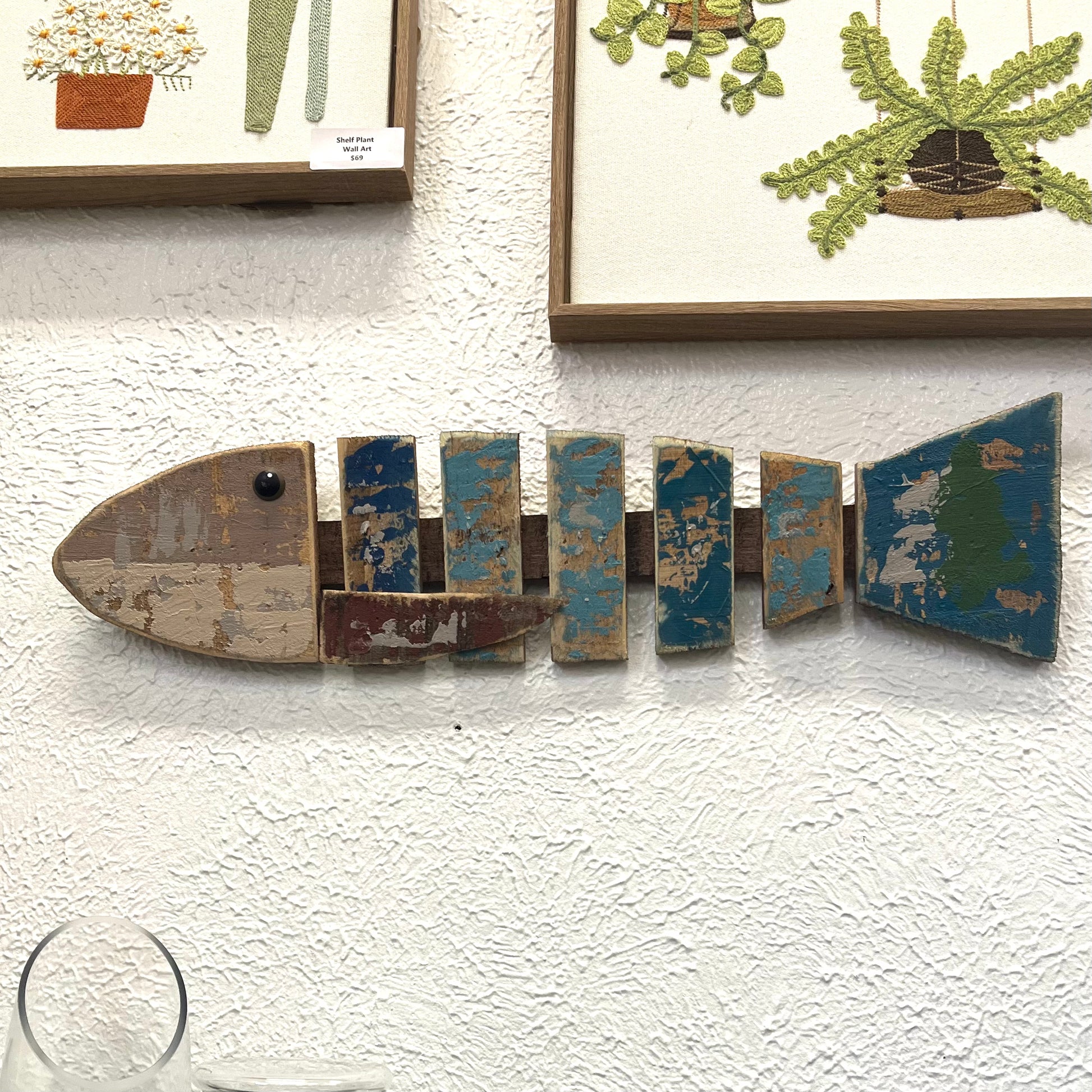 Decorative fish-shaped wall art with a textured white background